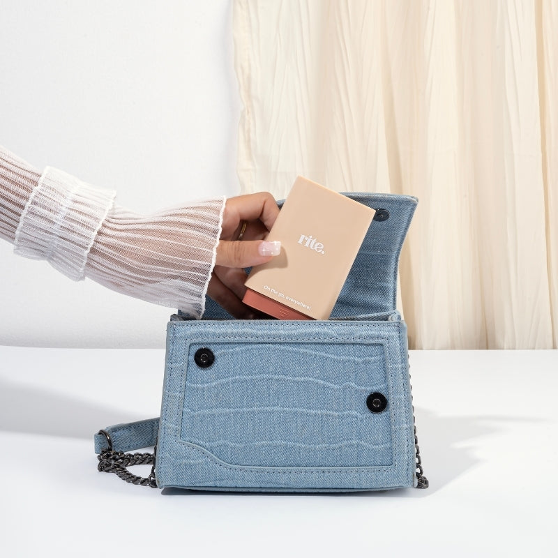 A woman with a blue purse and, standing beside a gummies dispenser.