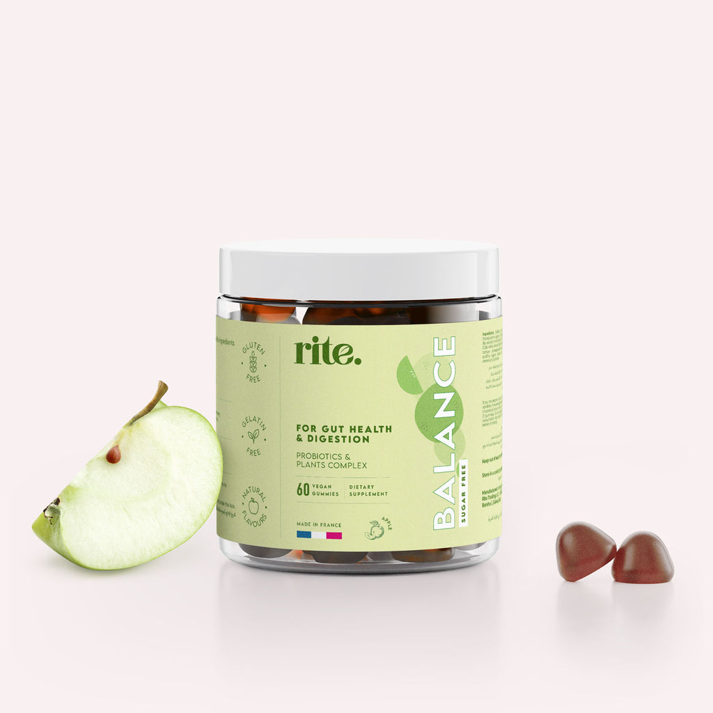 "A jar of Rite BALANCE Vegan Gummies sits on a table next to a green apple.   "