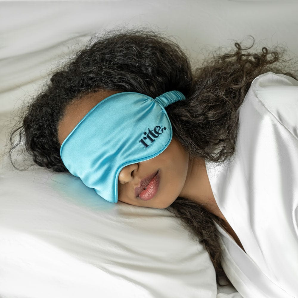 Woman wearing an eye mask and resting on a pillow.